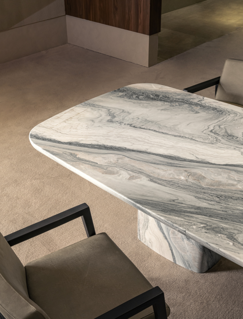 Overhead view of marble dining table and upholstered chairs on rug