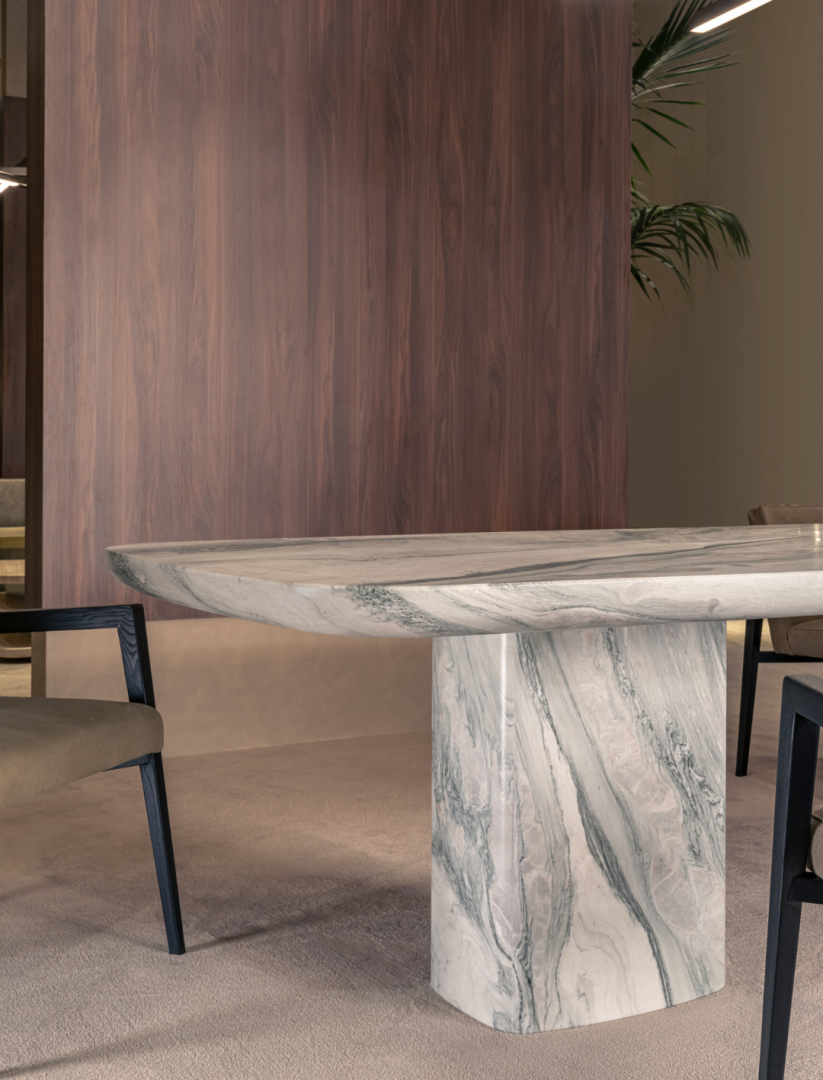 Marble dining table base, dark wood wall, beige chair. Dining furniture.