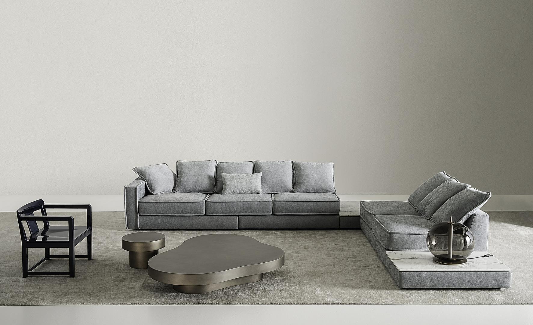  Modern living room featuring a gray modular sofa, unique coffee table, Casamilano side table, accent chair, and decorative lamp