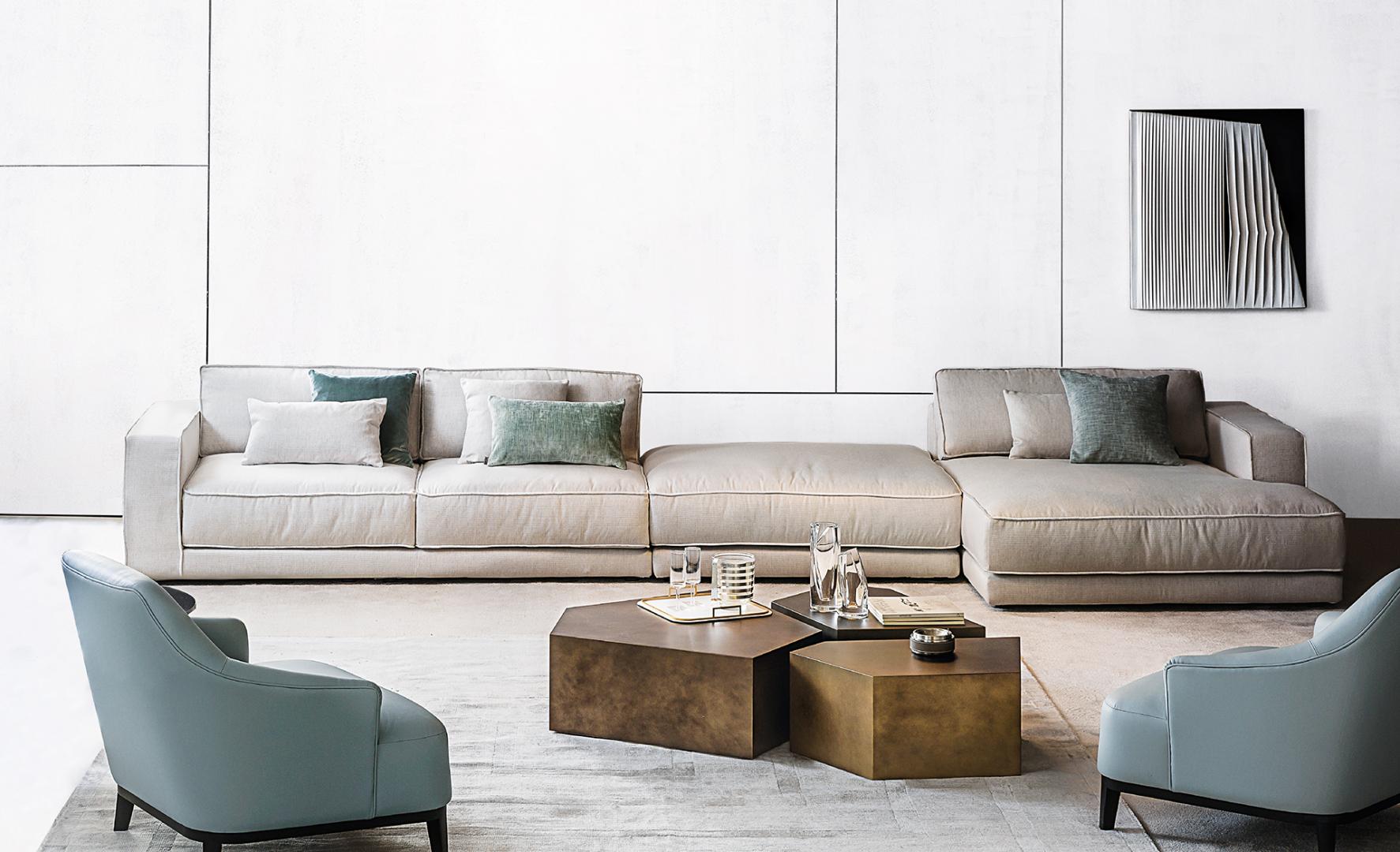  Modern living room with beige modular sofa, light blue Casamilano Arne armchairs, and geometric metal coffee tables for a minimalist interior