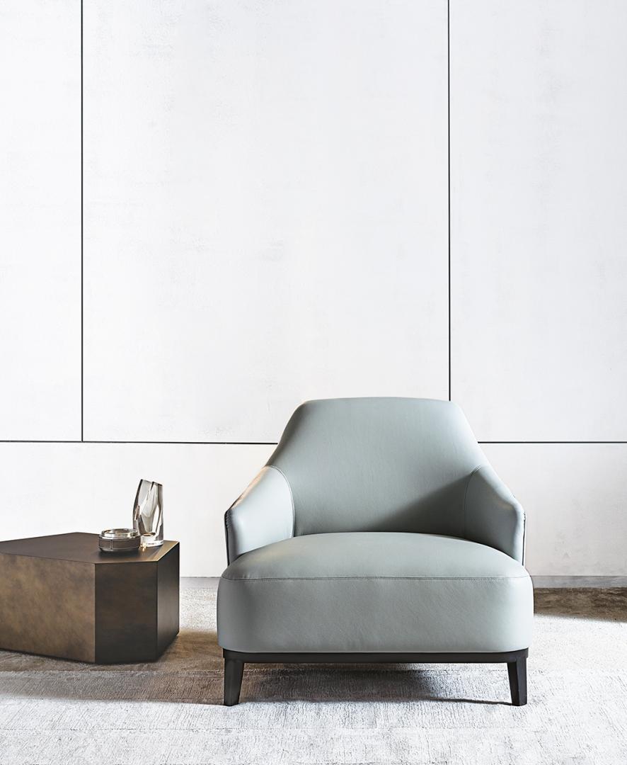 Modern living room featuring a light gray leather Casamilano Arne armchair and geometric side table; perfect for contemporary interior design