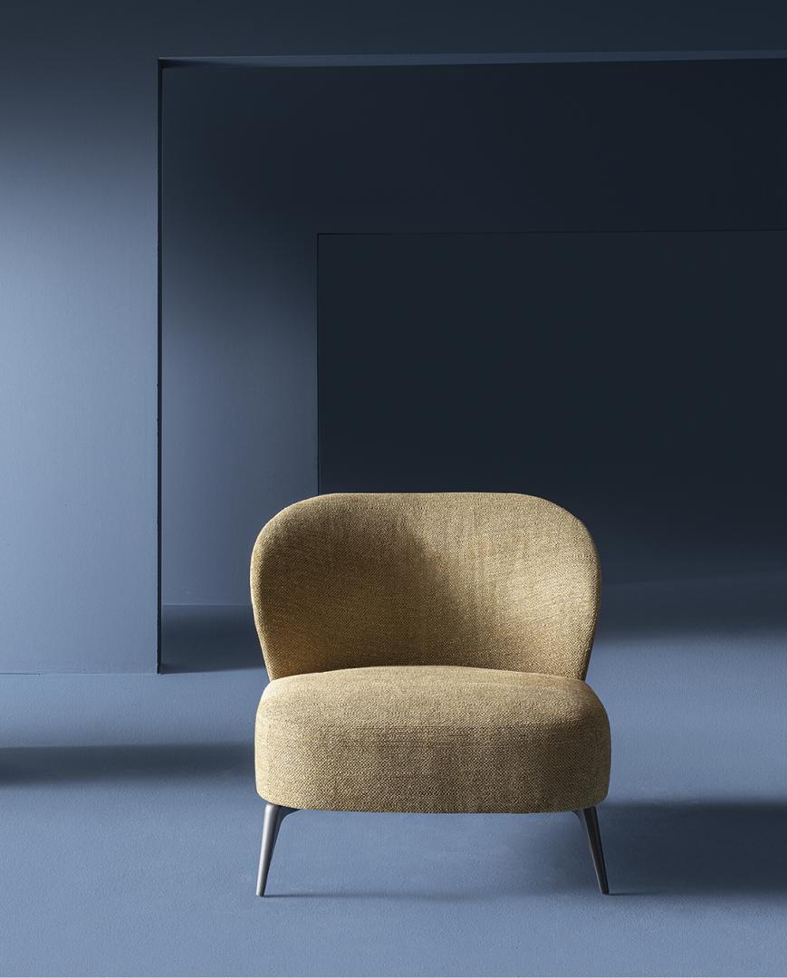  Front view of the Casamilano Dhora Slim armchair. Upholstered seat, rounded back, sleek metal legs, modern design, stylish seating