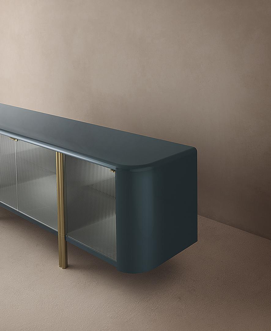 Close-up of the Casamilano Tecla sideboard featuring a blue finish, ribbed glass doors, and gold legs, perfect for modern storage