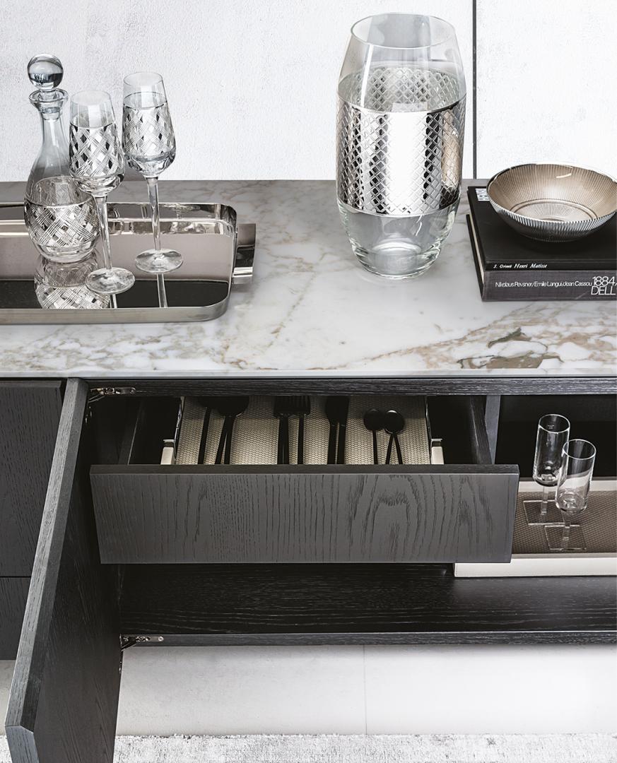  Close-up of the Casamilano Arne Sideboard featuring a dark wood finish, marble top, and open drawer with organized silverware
