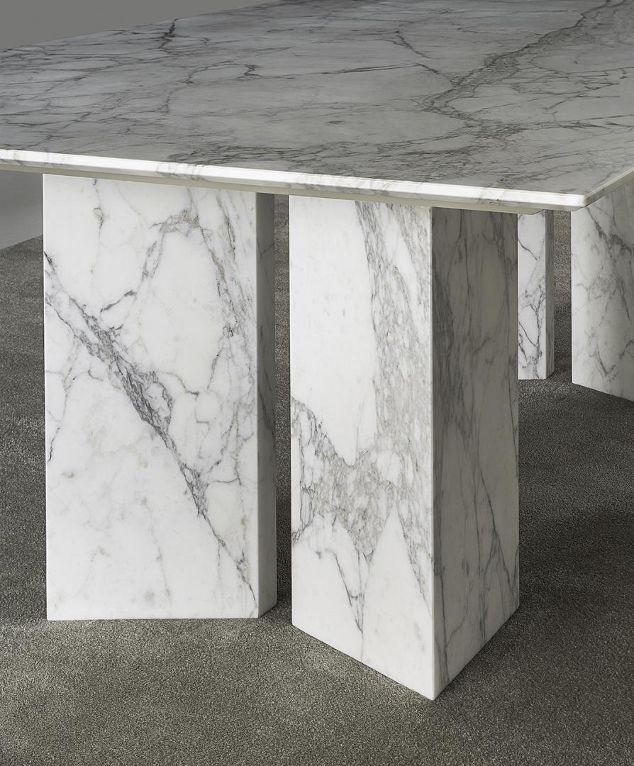 Close-up of the Casamilano Karl dining table featuring a white marble top with grey veining and geometric marble legs