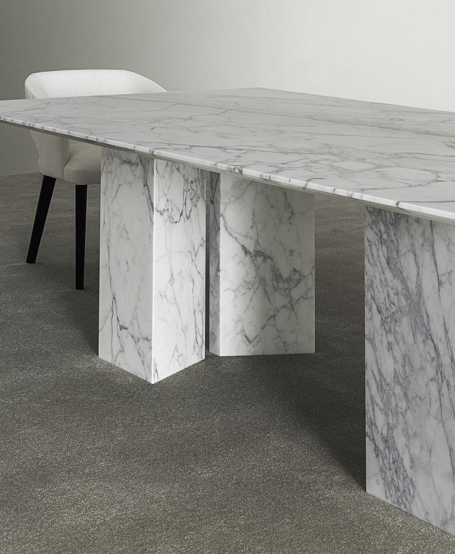  Close-up of the Casamilano Karl dining table featuring a marble top, block legs, and minimalist chair for luxury dining