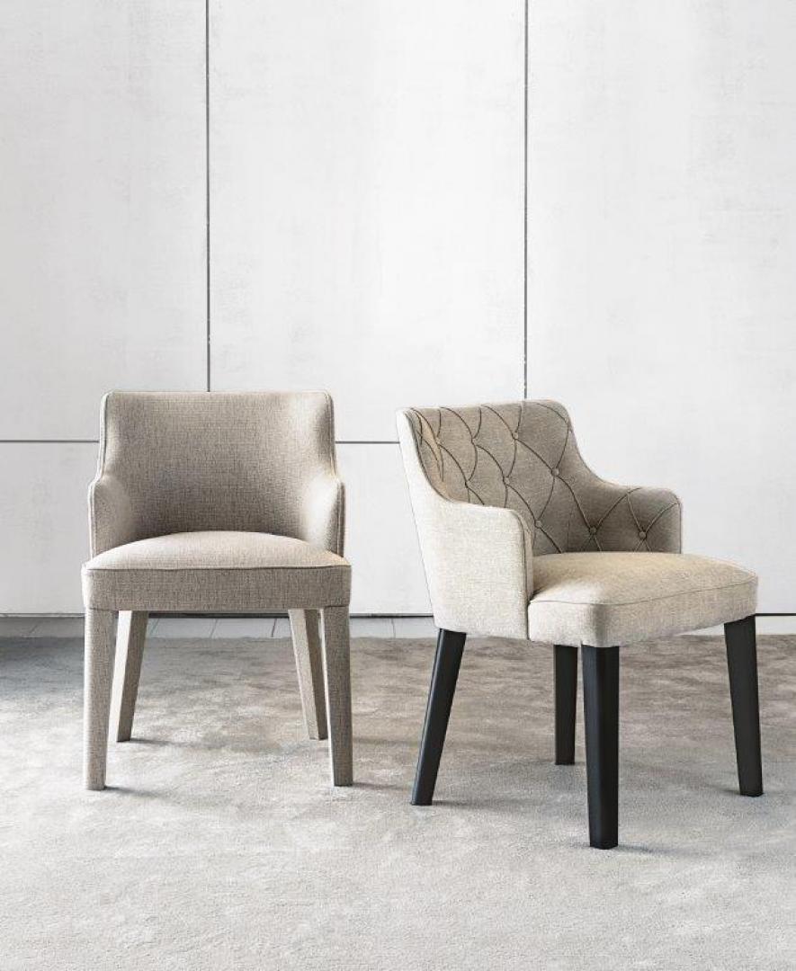 Two Casamilano Royale Capitonné dining chairs, one tufted, one sleek, upholstered in neutral tones against a white wall