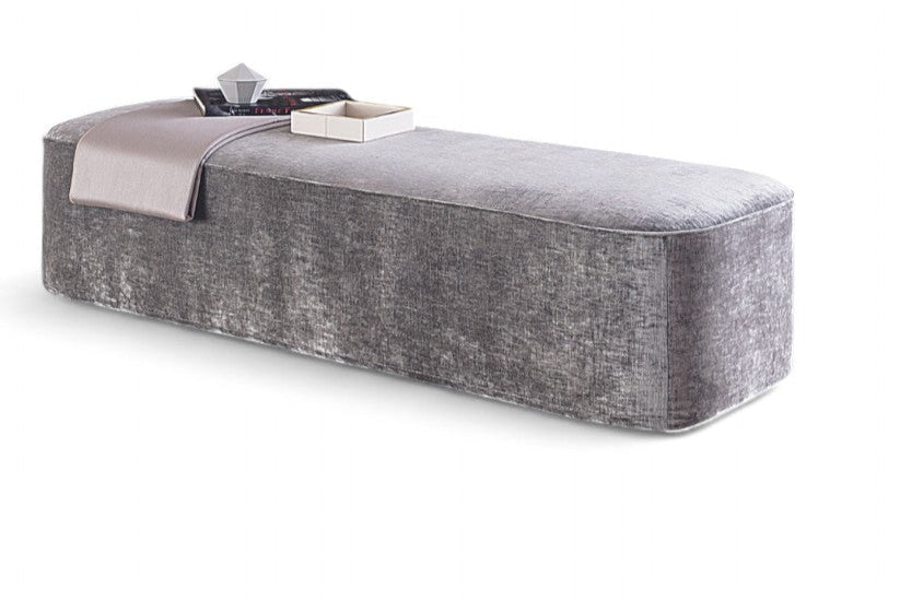 Gray upholstered bench with a small table and decorative items on a white background