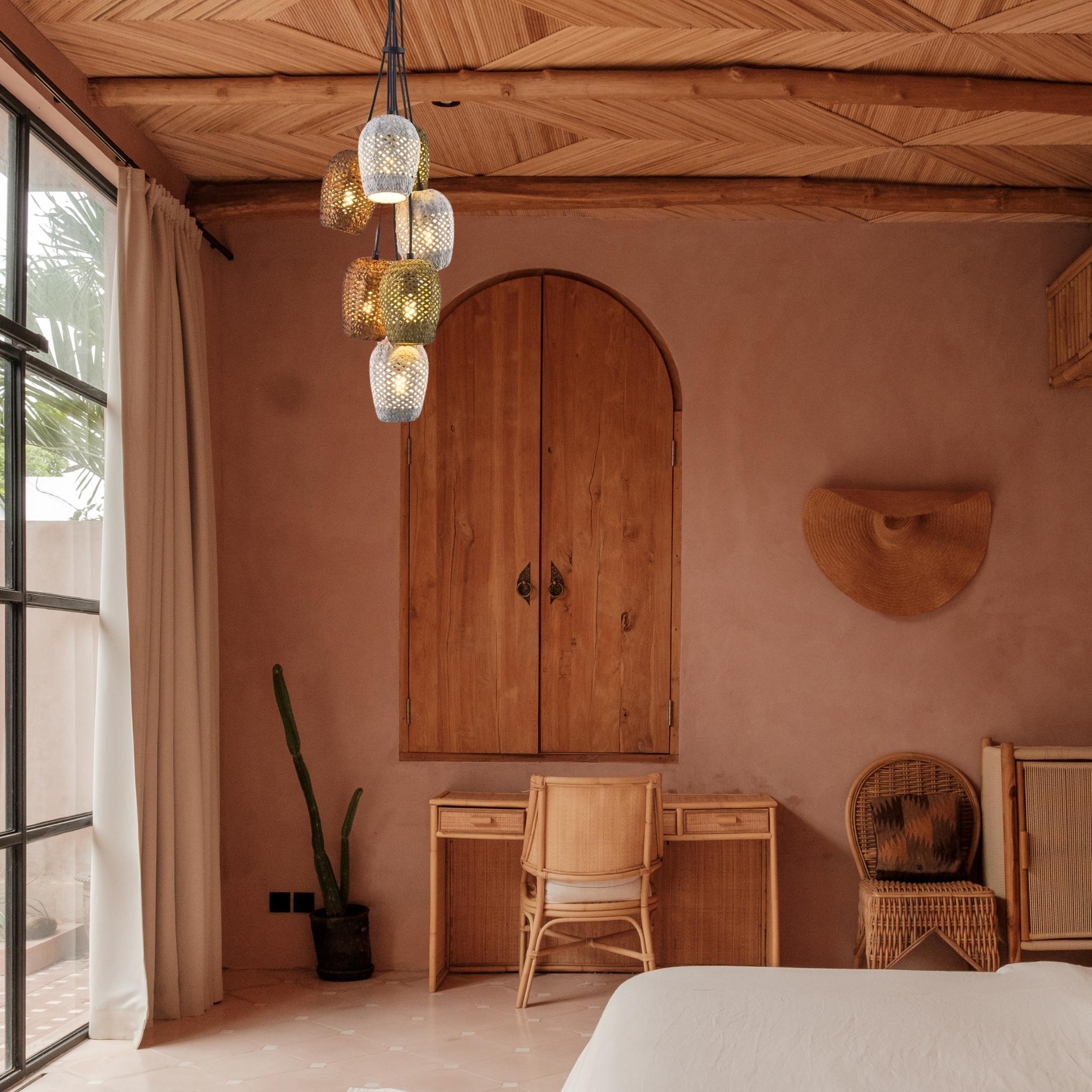 Bedroom view with woven rattan lighting, wood desk, and chair.