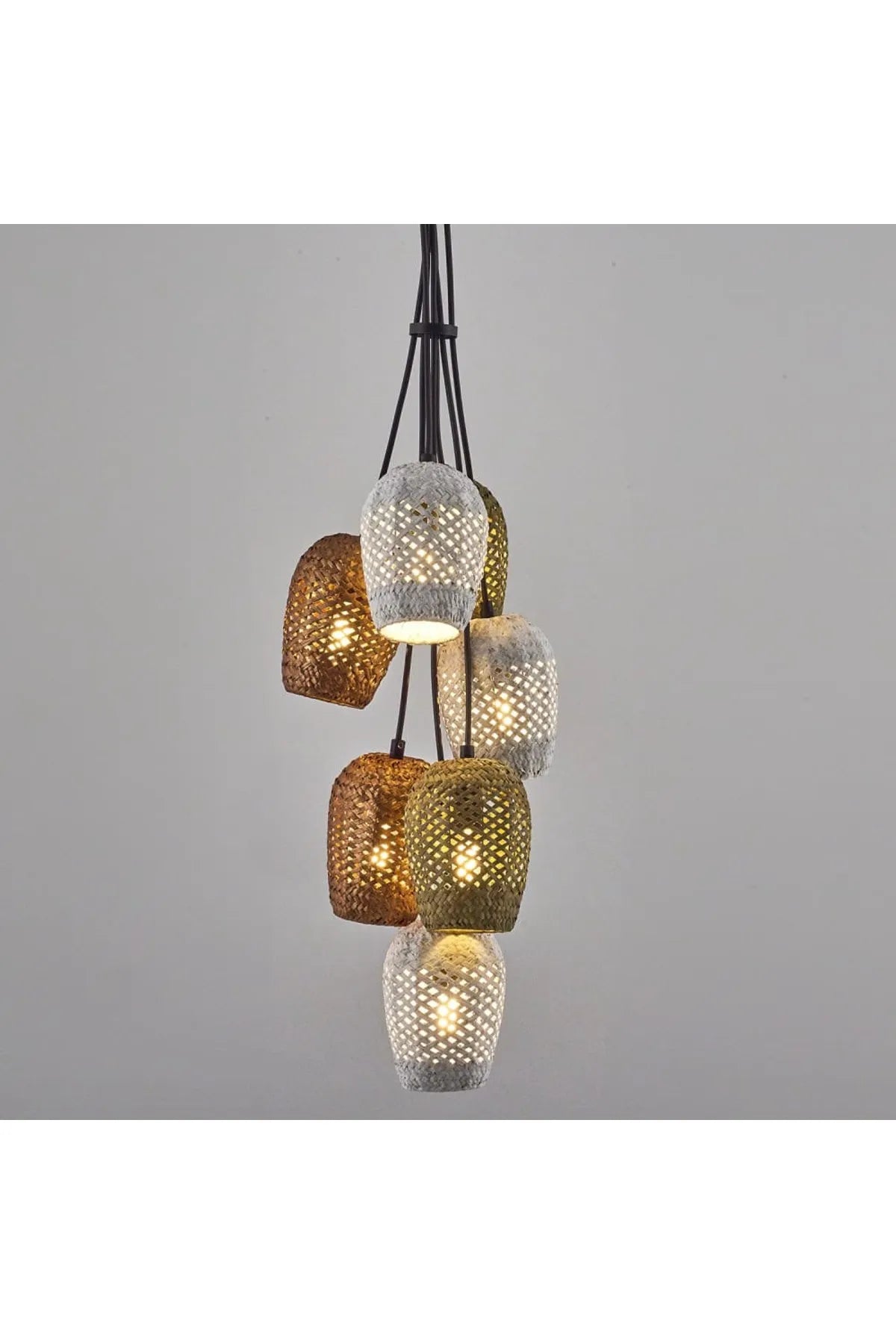 View of a multi-colored woven fiber cluster pendant lighting fixture hanging against a light gray wall.