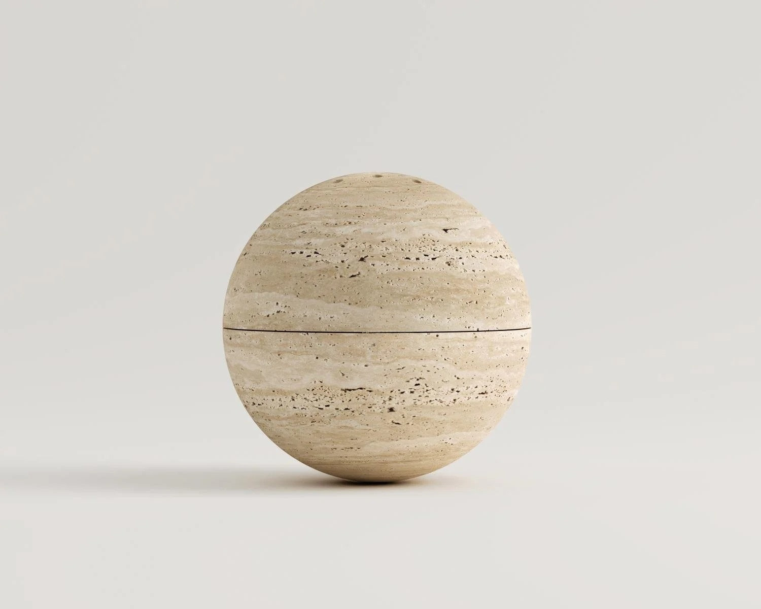 Travertine sphere decor with horizontal dividing line on white background