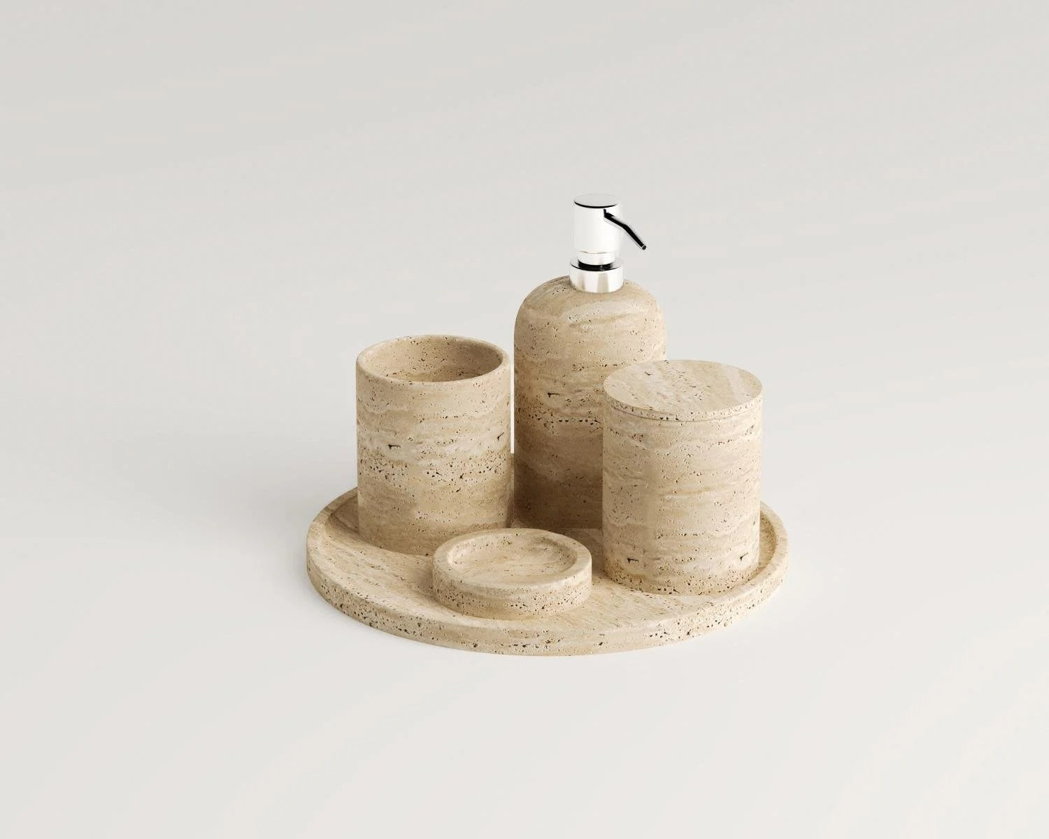 Travertine bathroom accessories set including soap dispenser and tray on white background.