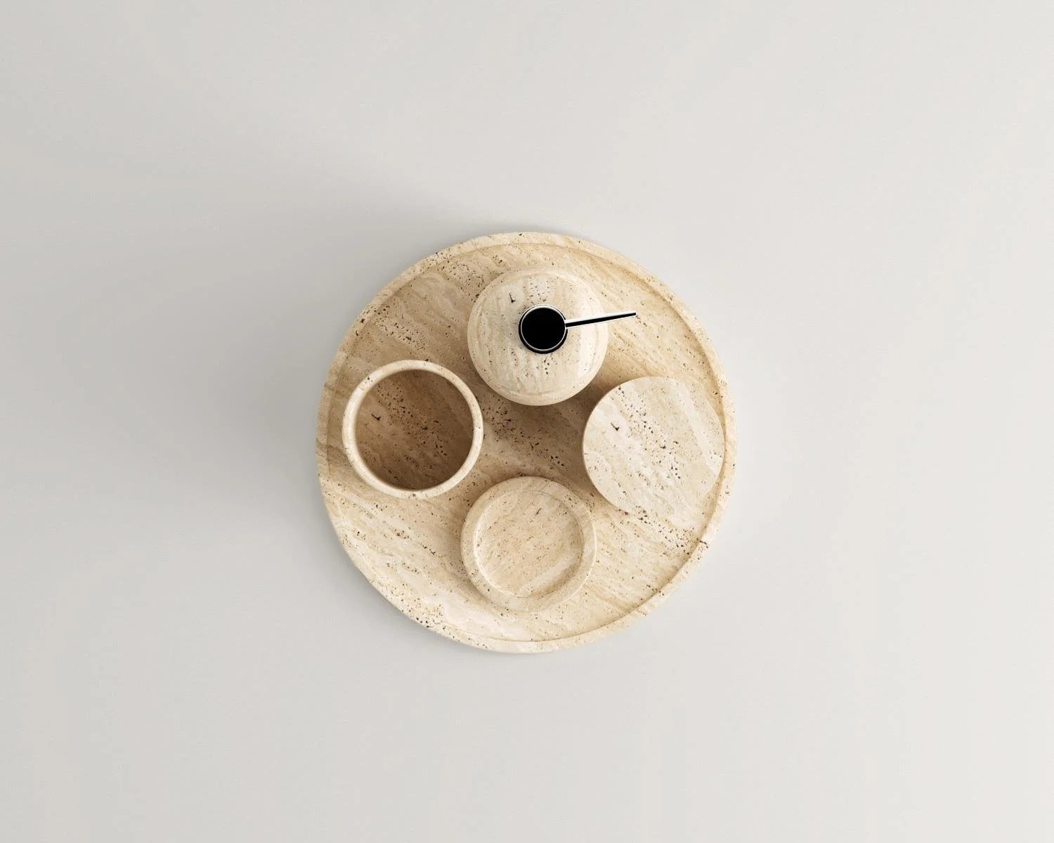 Overhead view of round travertine tray with matching decor pieces