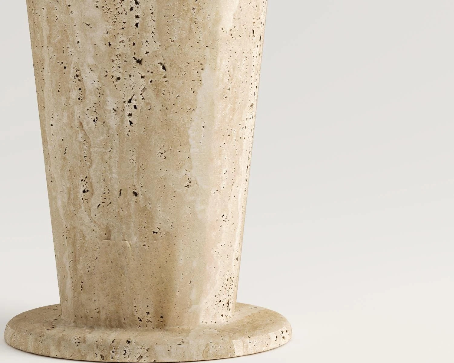 Close up view of beige travertine stone vase base on white background