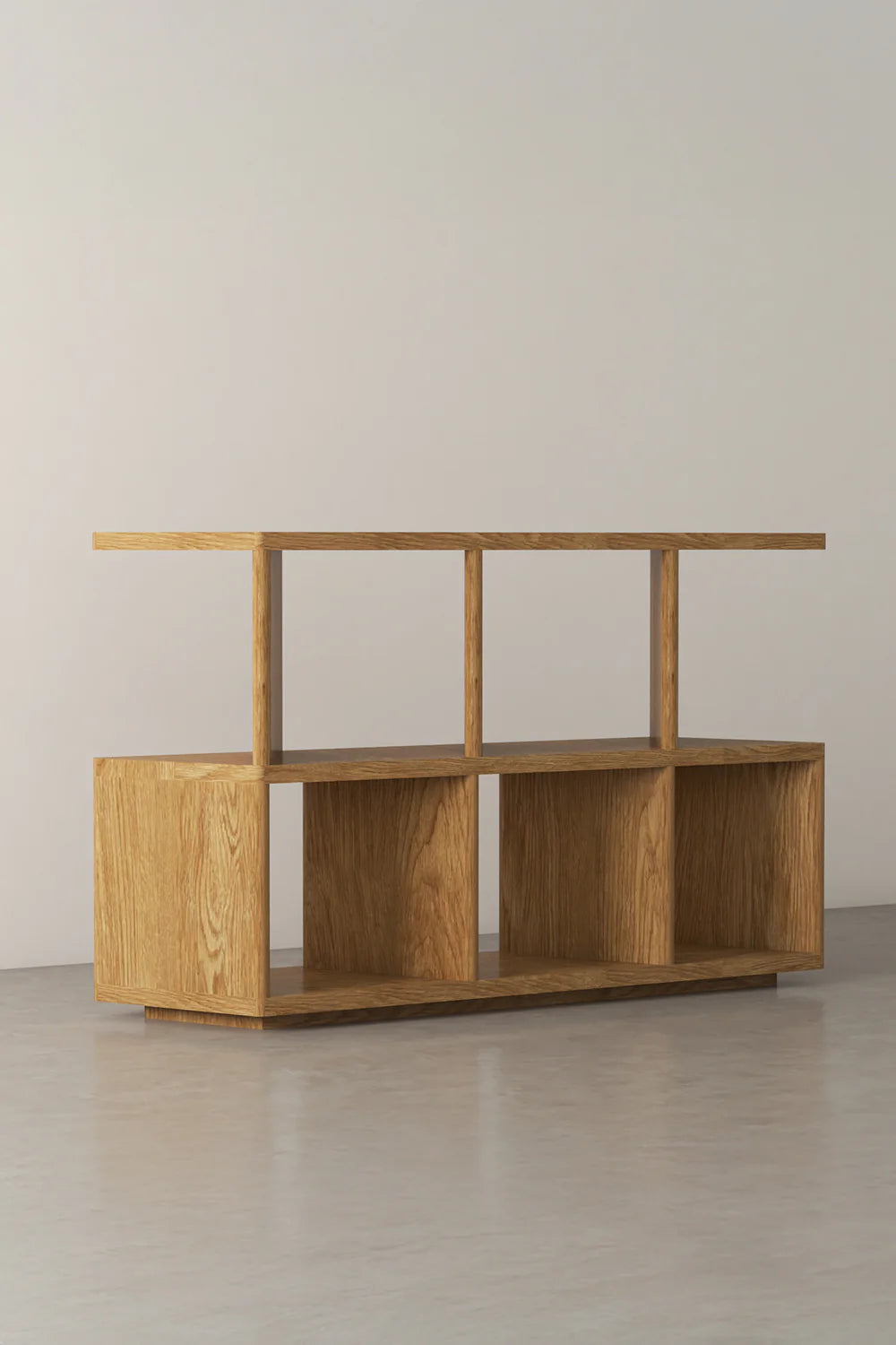 View of a light wood shelving unit with open cubbies on a gray floor.
