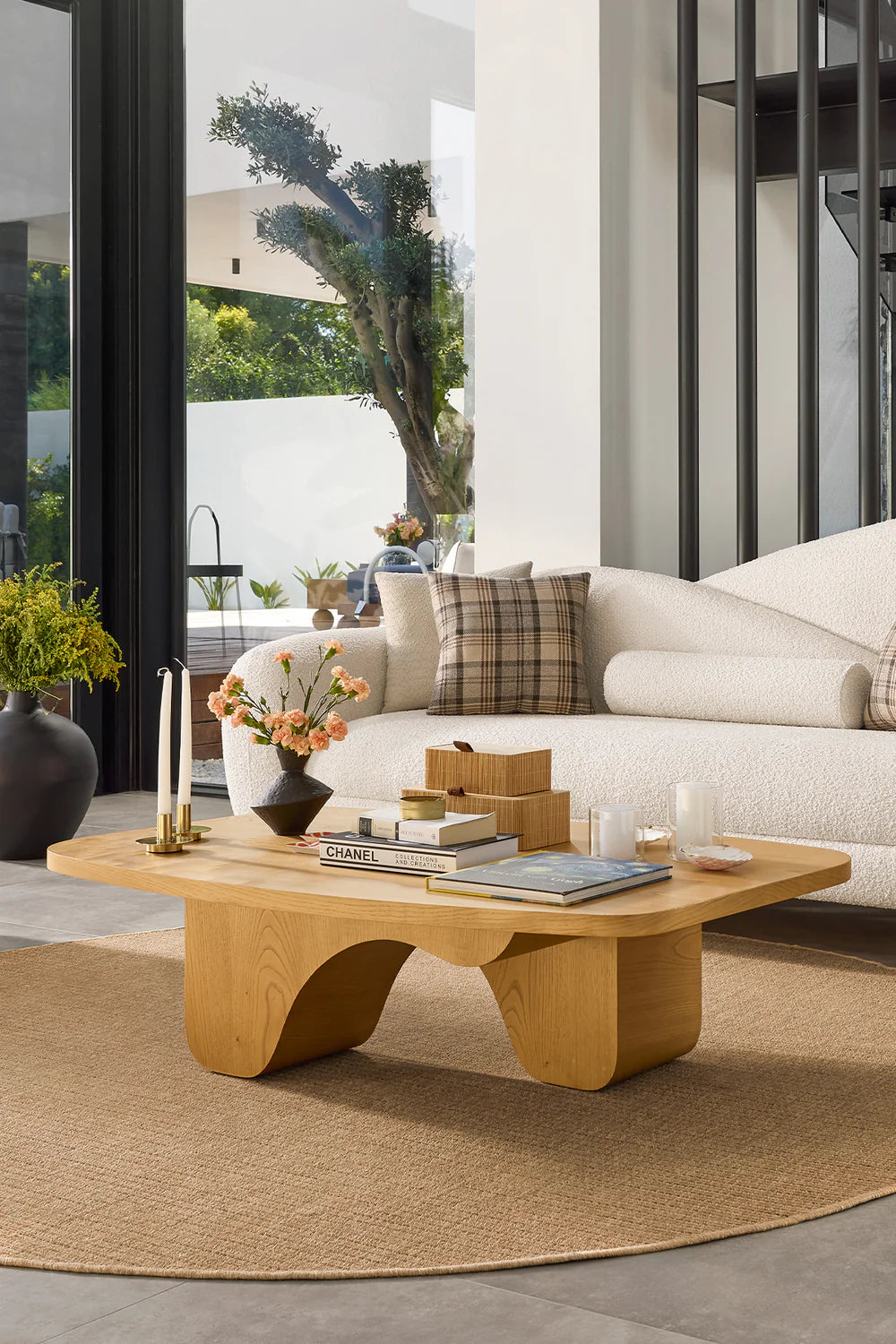 Living room interior with light wood coffee table and white sofa.