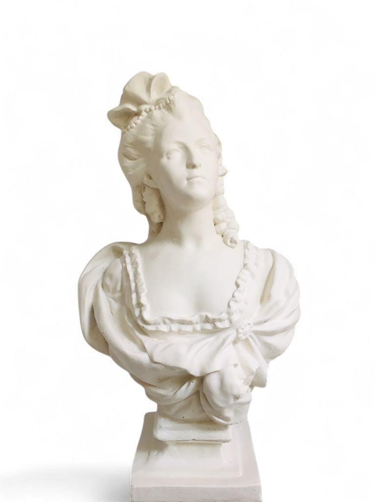 White plaster bust sculpture of a woman on a pedestal