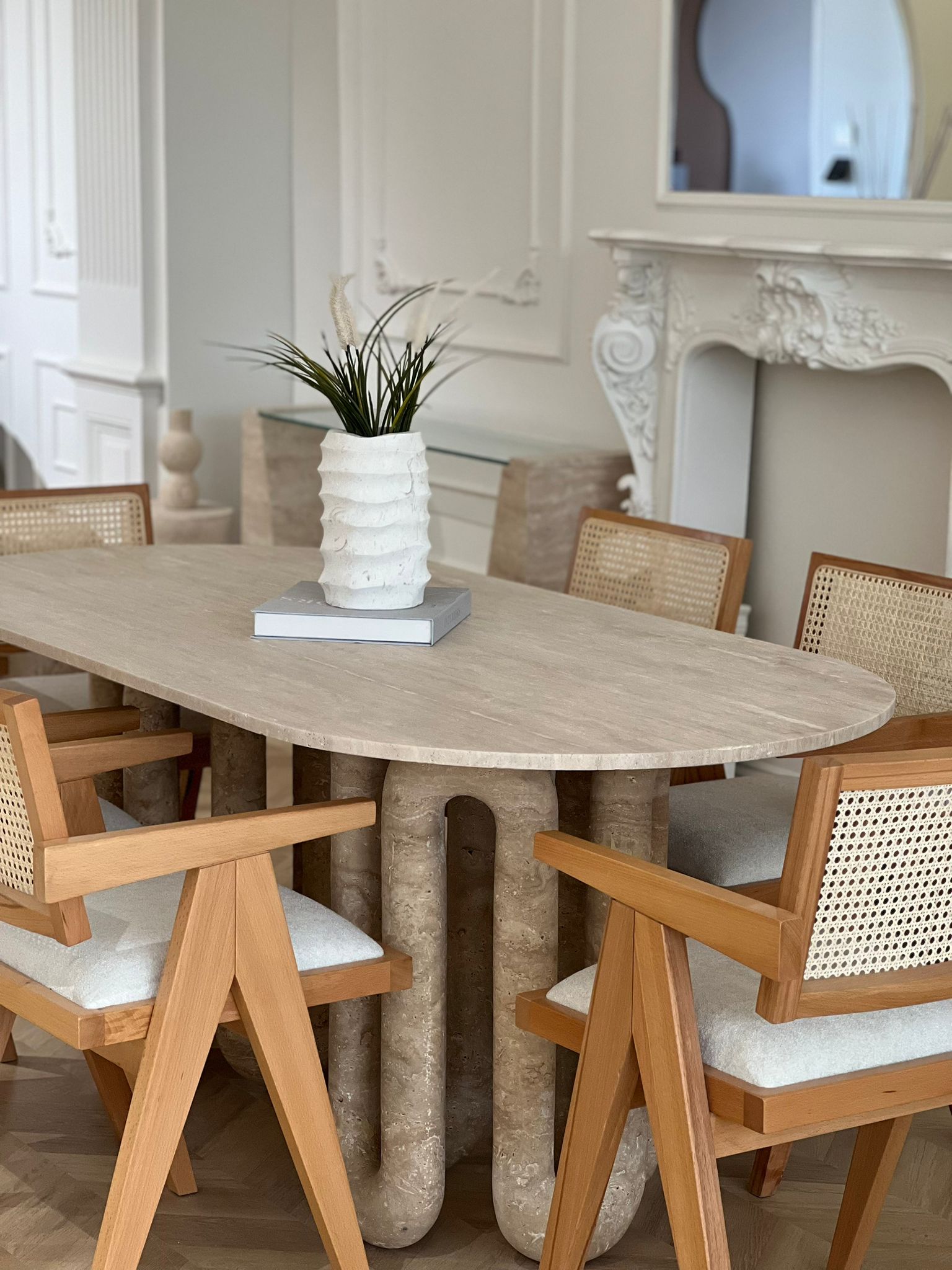 Luzione Celestia Travertine Dining Table with cane back chairs in a modern dining room setting showcasing luxury furniture and contemporary design