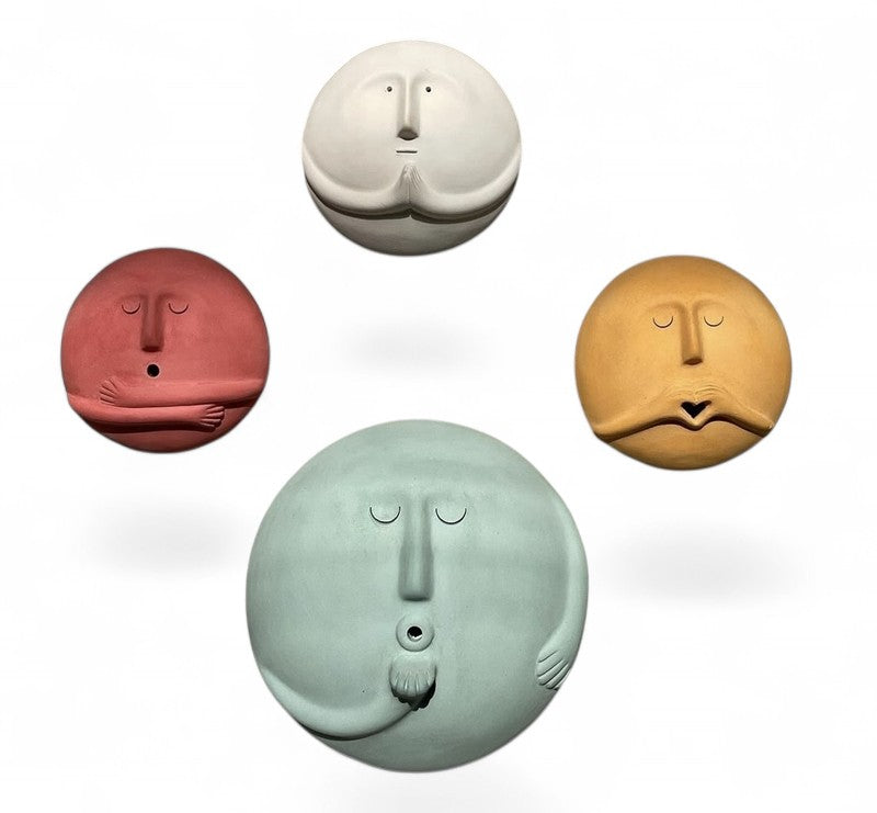 Four colorful round face sculptures with arms wall decor