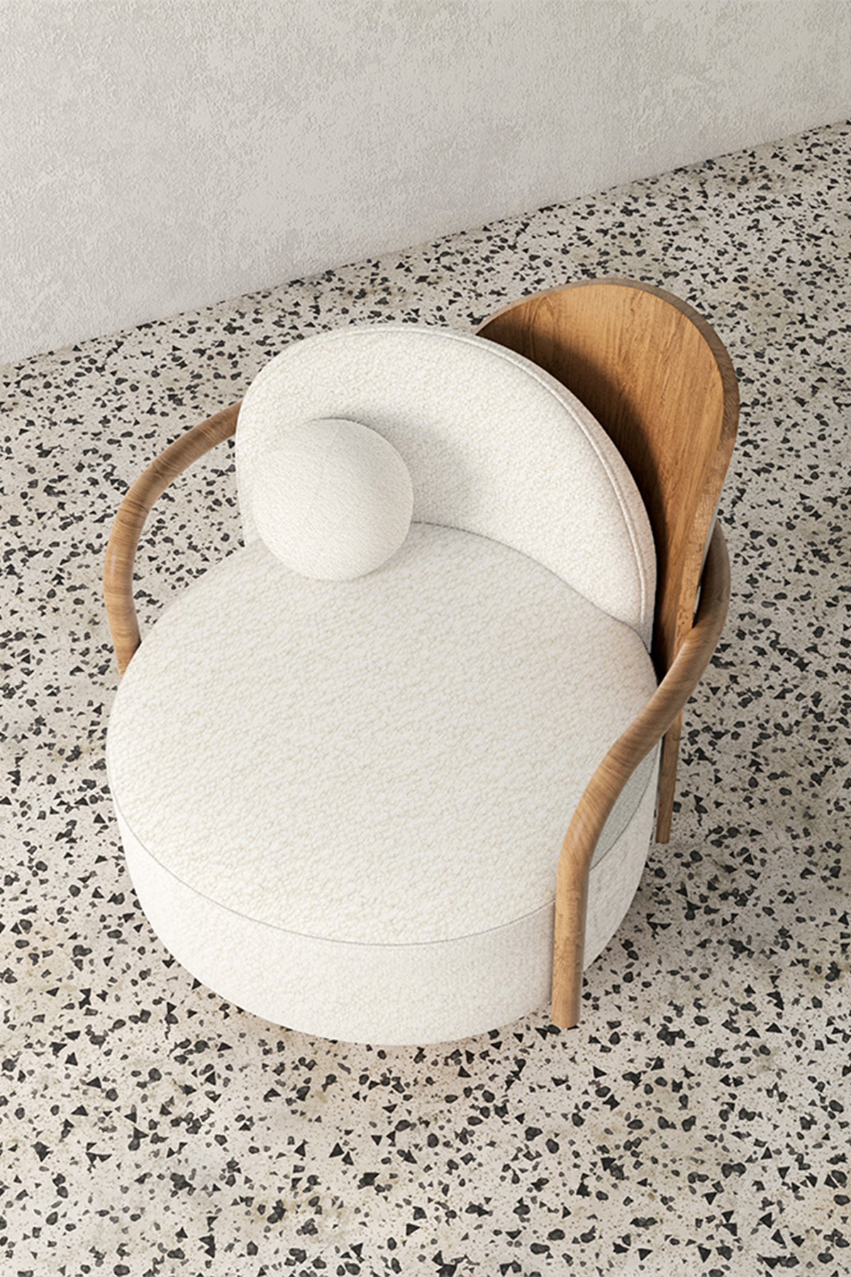 Overhead view of modern bouclé accent chair on terrazzo floor.