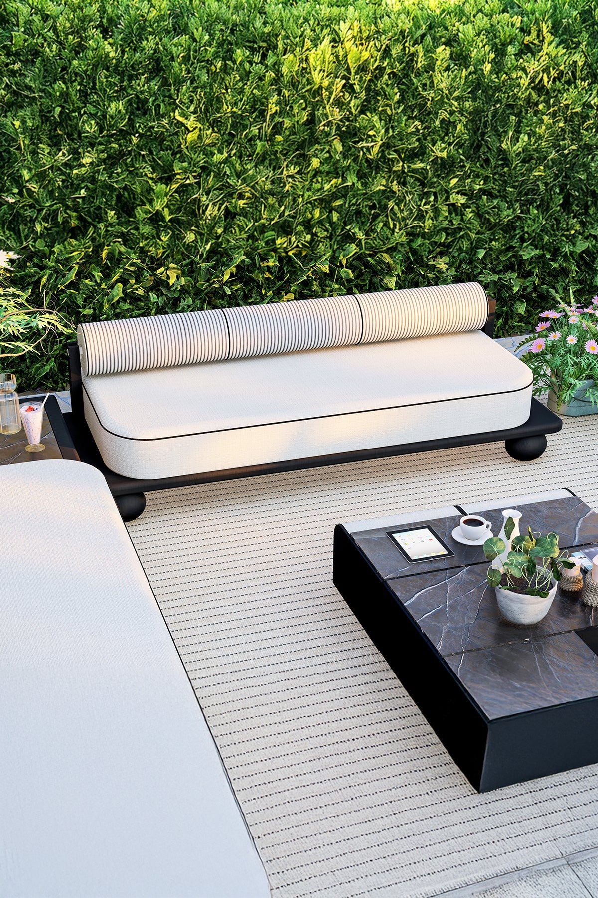 Outdoor patio scene with white cushioned sofa and dark marble coffee table.