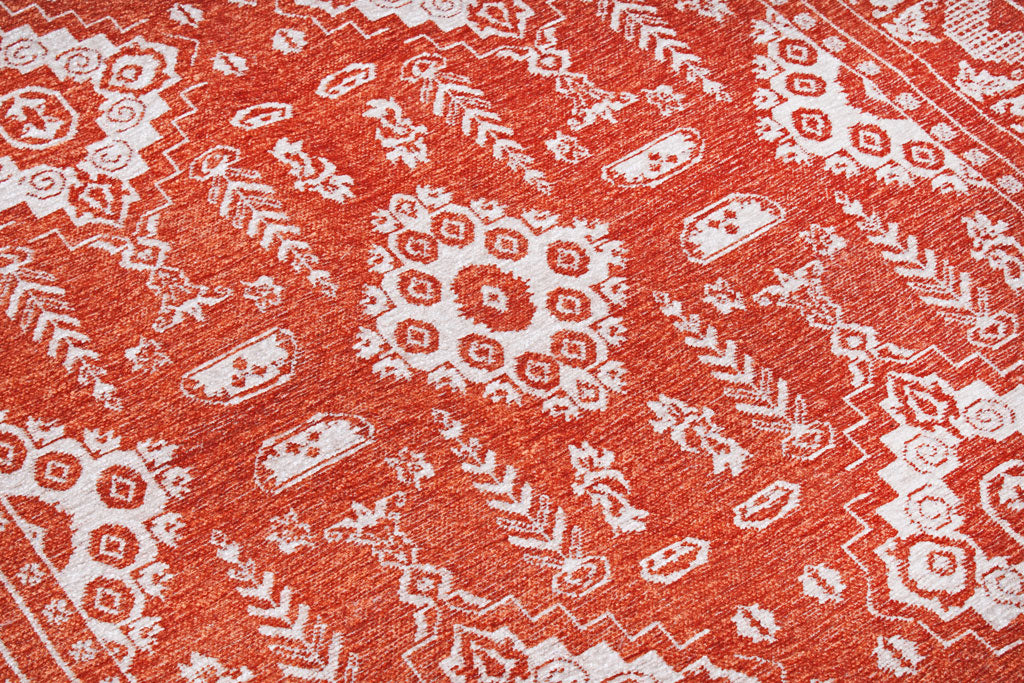 Close-up of orange and white patterned area rug texture.