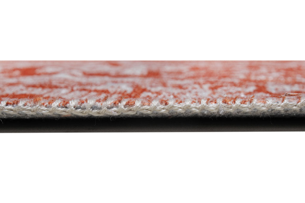 Close up view of orange and white rug edge binding