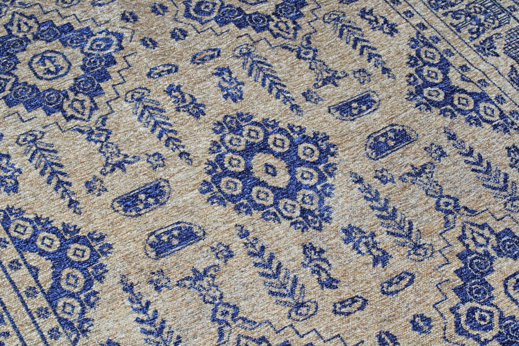 Close up view of beige rug with blue geometric pattern