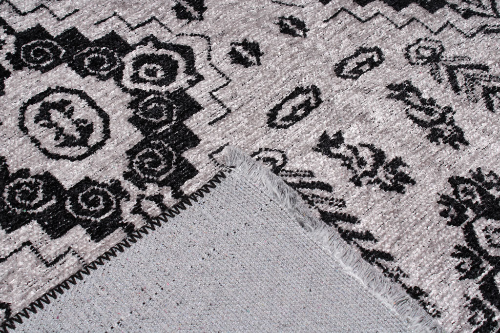 Close up view of gray and black patterned rug showing backing