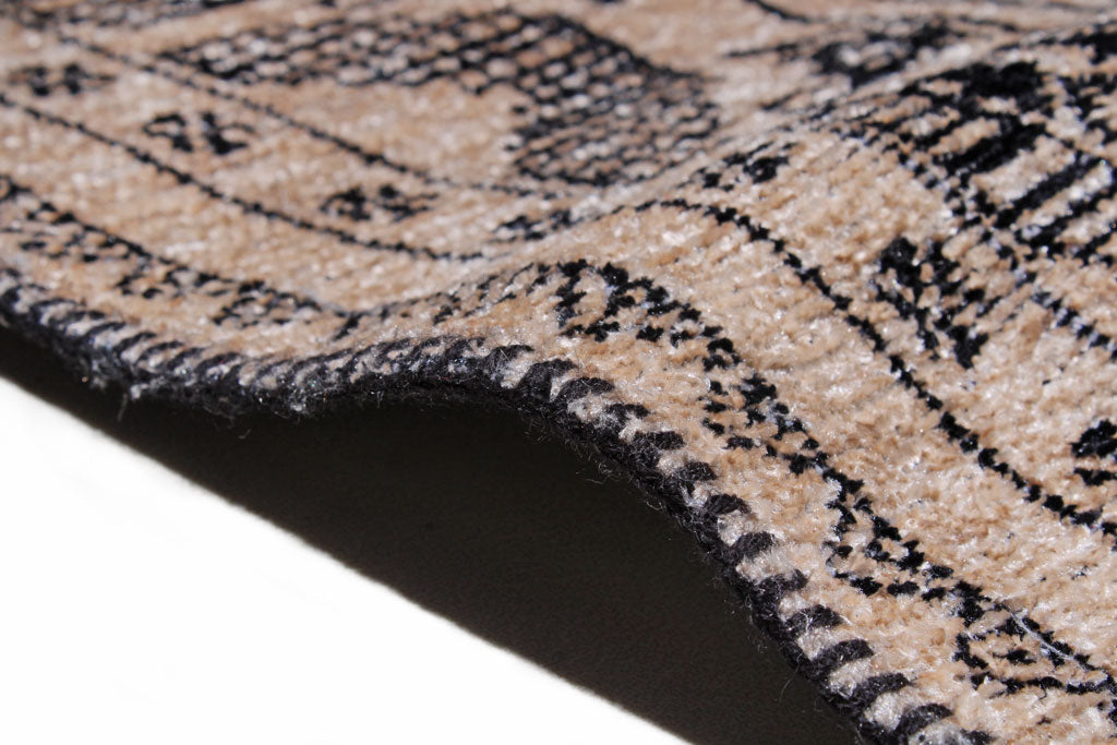 Close up view of beige and black patterned rug edge