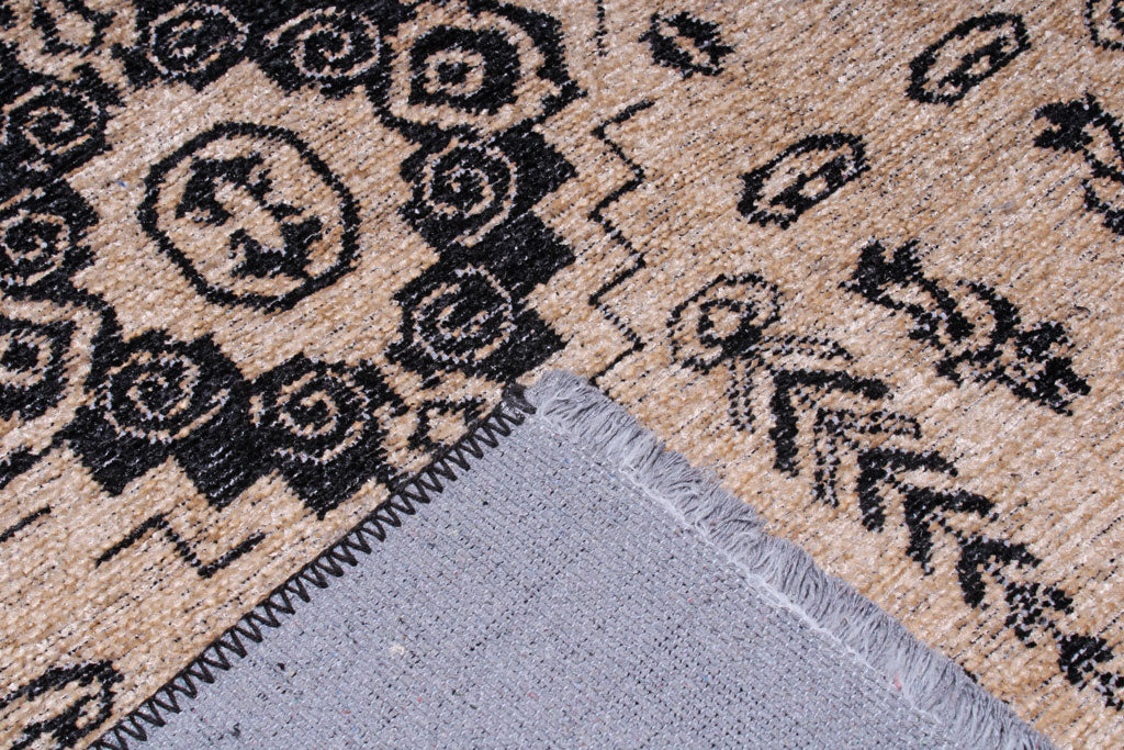 Close up view of beige and black patterned rug showing backing