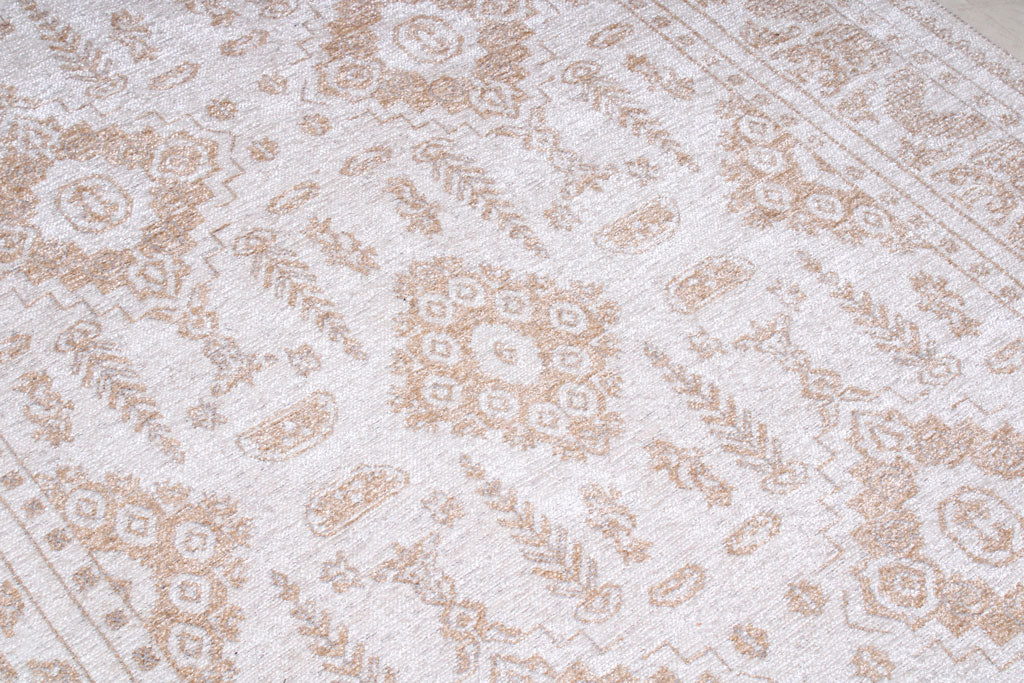 Close up view of white and tan patterned area rug