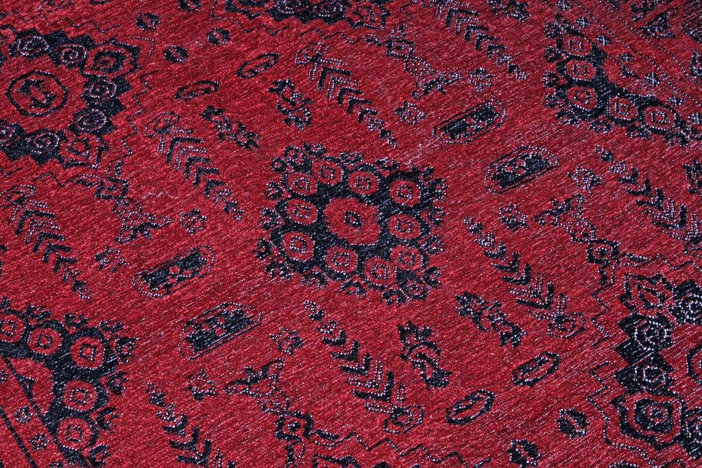 Close up view of red rug with black geometric patterns