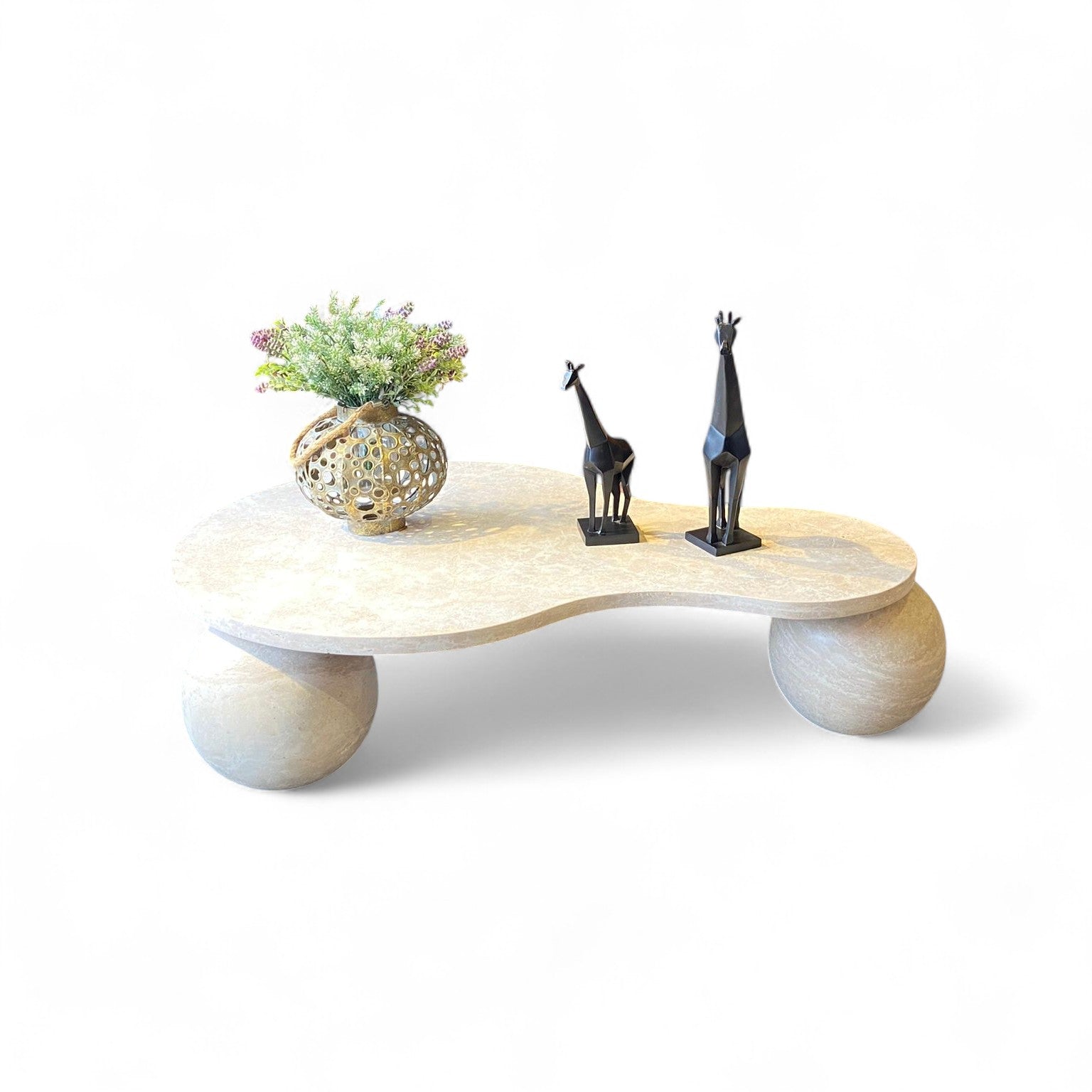 Studio shot of beige stone coffee table with black giraffe sculptures and vase. Modern organic coffee table, stone furniture, giraffe sculptures, home decor, accent table, living room furniture, unique table design.