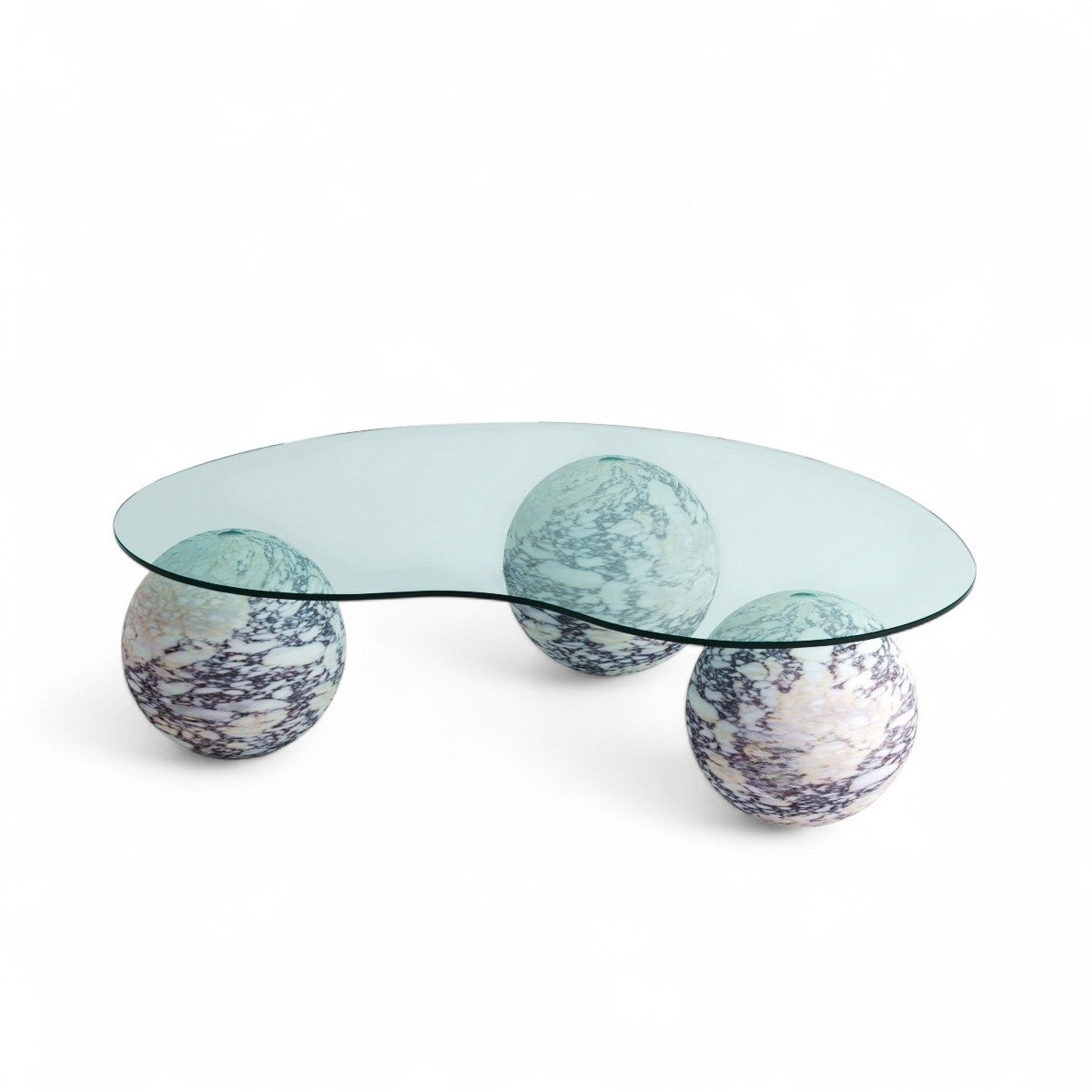 View of modern glass coffee table with three marble sphere bases. Modern furniture, glass table, marble spheres, coffee table, interior design.