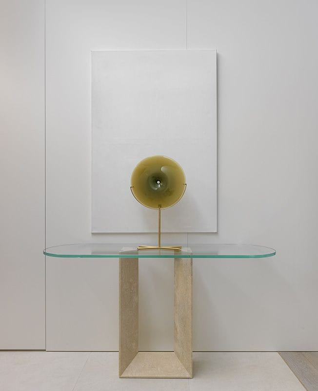 Modern entryway featuring the Luzione Livia console table with a glass top and geometric stone base, complemented by minimalist decor and neutral tones