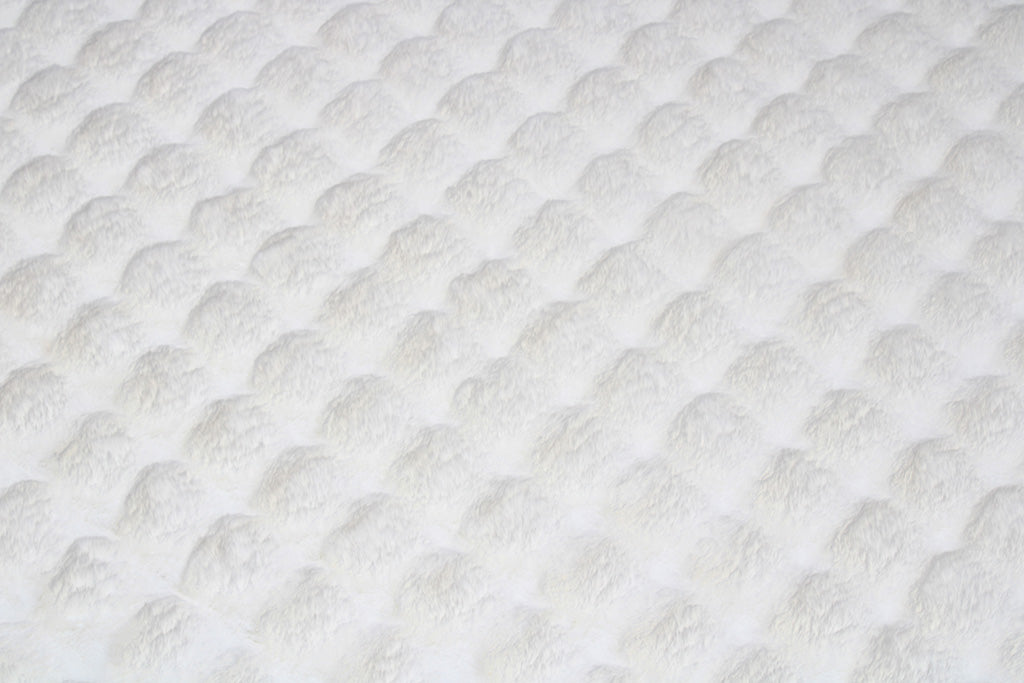 White textured fabric with raised circular pattern textile