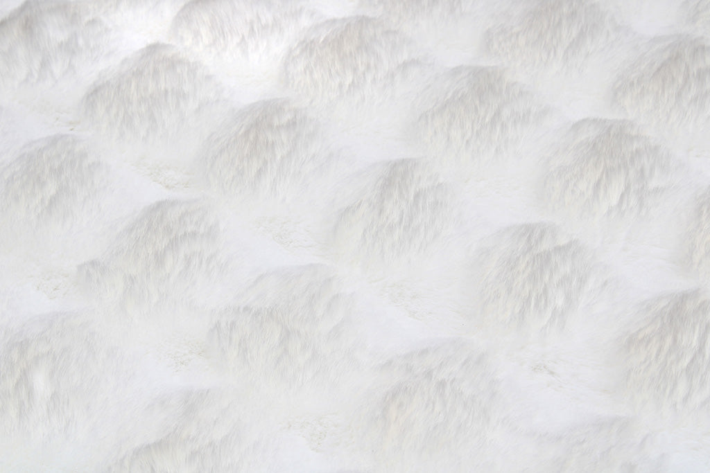 White faux fur textured blanket or rug close up