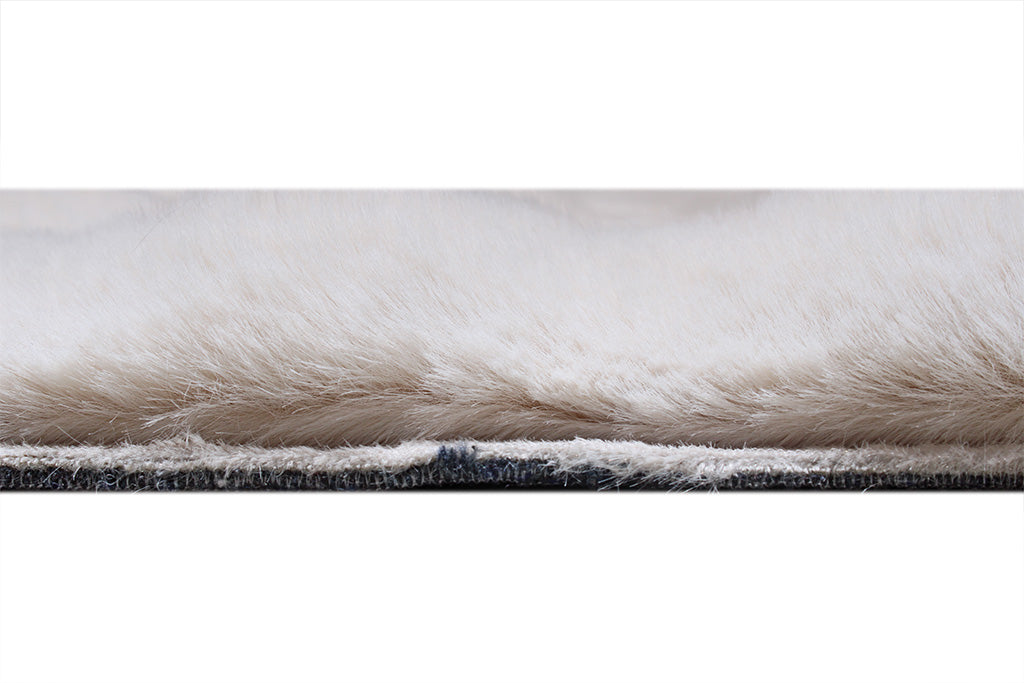 Close up view of white faux fur rug pile and backing