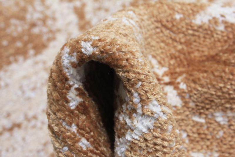 Close up view of rolled brown and white patterned rug