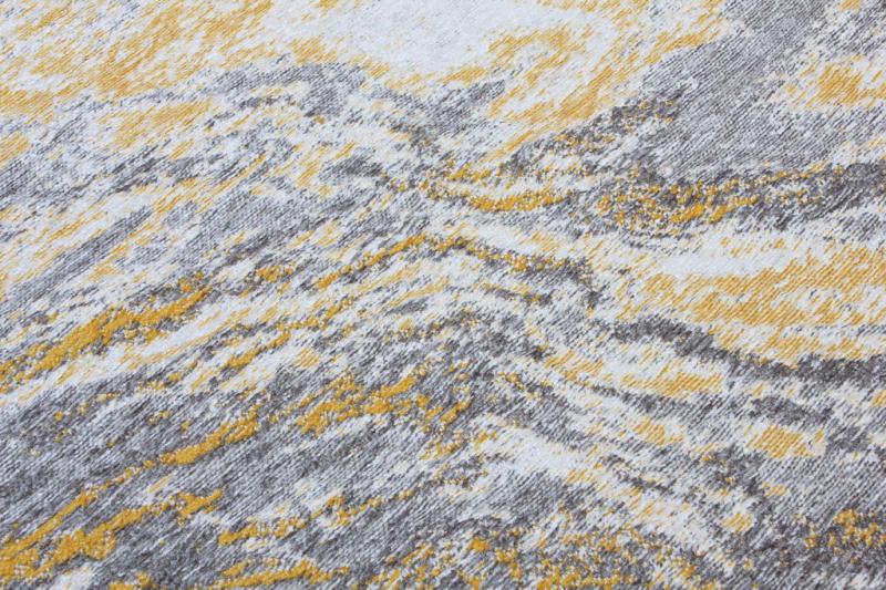 Close-up view of abstract patterned rug in yellow, gray, white colors