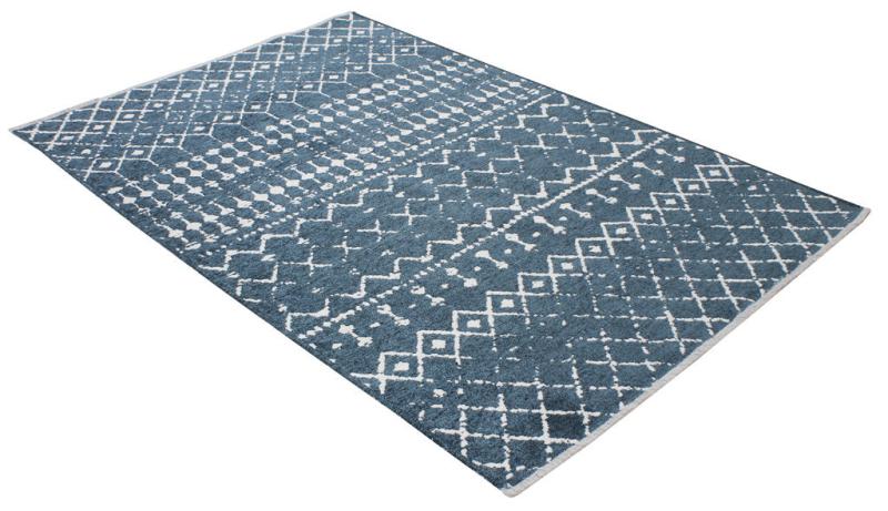 Overhead view of blue and white patterned area rug on white background