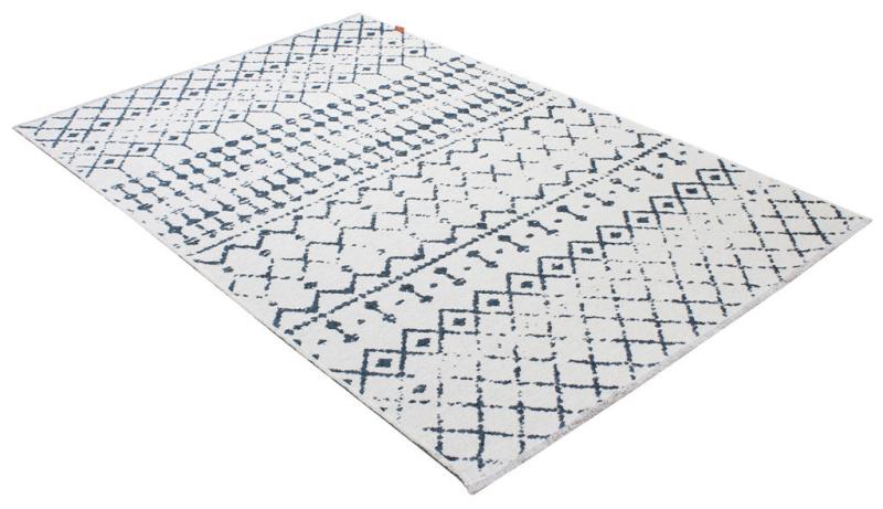 White and blue patterned area rug with geometric design