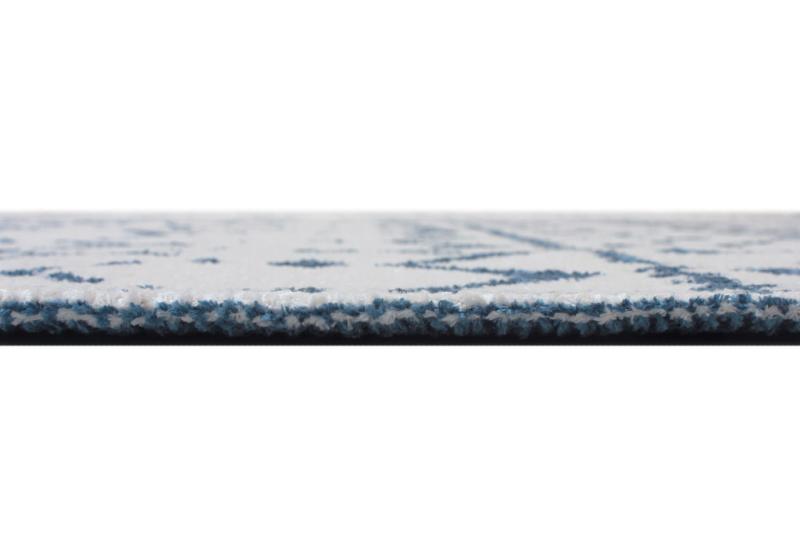 Close up view of white and blue patterned rug edge