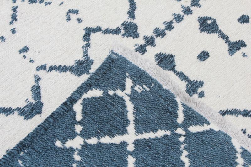 Close up view of white and blue patterned rug showing reverse side