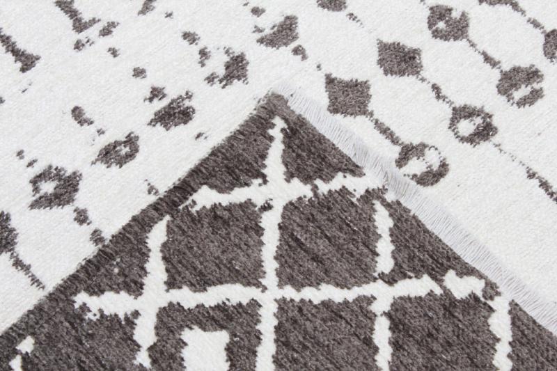 Close up view of white and gray patterned rug showing backing