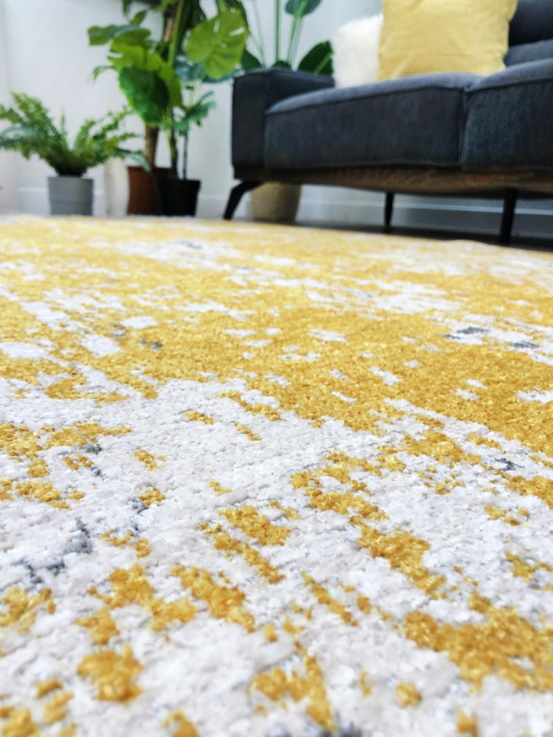Close up view of yellow and white abstract patterned rug