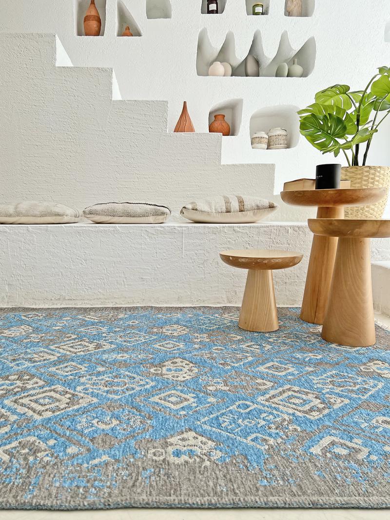Blue gray patterned area rug on floor with wooden tables