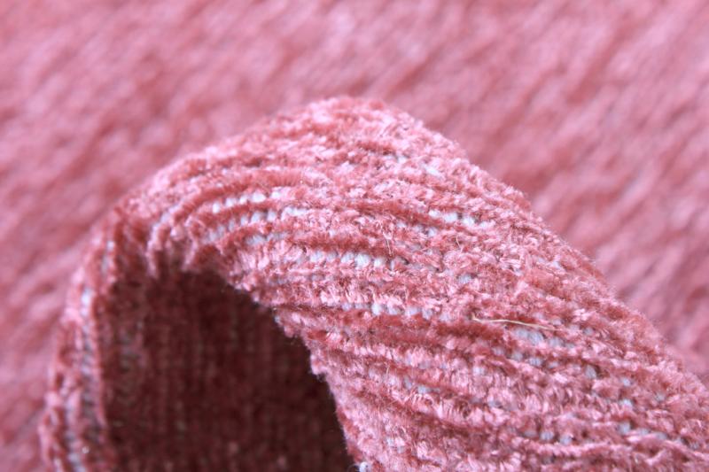 Close up pink textured fabric fold showing weave