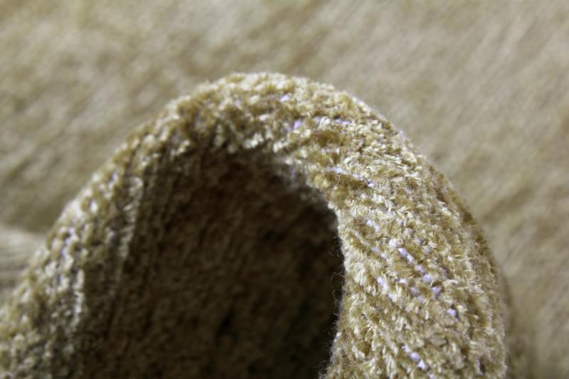 Close-up of Moretti Plain Rug's fibers, showcasing the softness and quality of its beige material.